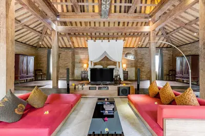 a living room with a red couch and a tv at Wahyu wonderful 4Bd villa with huge garden and 2 pools in Seminyak