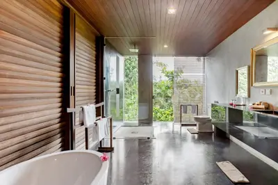 a bathroom with a large tub and a large window at Wahyu wonderful 4Bd villa with huge garden and 2 pools in Seminyak