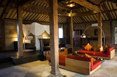 a living room with two couches and a bed at Wahyu lux honeymoon joglo 2 in Seminyak