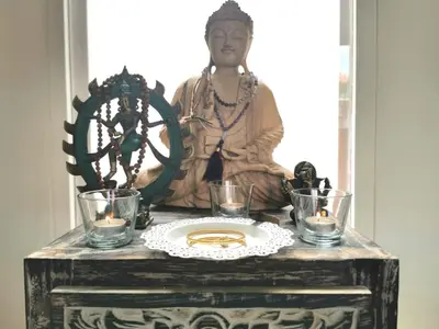 a statue of a woman sitting on a table with candles at Kubu Garden Suites & Villas Nusa Dua in Nusa Dua