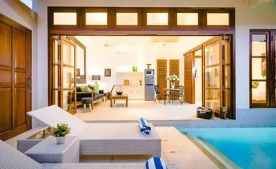 a house with a swimming pool and a living room at Villa Bella Seminyak in Seminyak