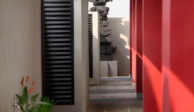 a hallway with red and white walls and a stair case at Amaris Hotel Sunset Road - Bali in Kuta
