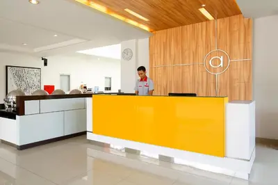a man standing behind a yellow counter in a room at Amaris Hotel Sunset Road - Bali in Kuta