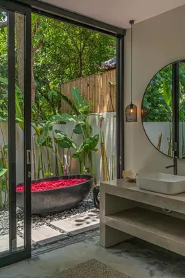 a bathroom with a bath tub and a mirror at Villa Prana - High End Boutique Style Interior Design 5 BR Villa in Canggu