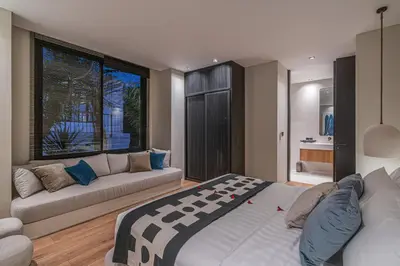 a bedroom with a large bed and a couch at Villa Prana - High End Boutique Style Interior Design 5 BR Villa in Canggu