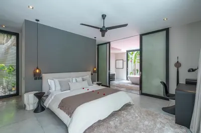 a bedroom with a large bed and a bathroom at Villa Prana - High End Boutique Style Interior Design 5 BR Villa in Canggu