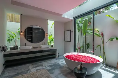 a bathroom with a large tub filled with red rocks at Villa Prana - High End Boutique Style Interior Design 5 BR Villa in Canggu