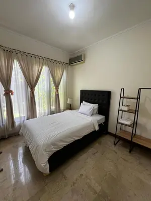 a bedroom with a large bed and a window at Turtledove Guesthouse in Kerobokan