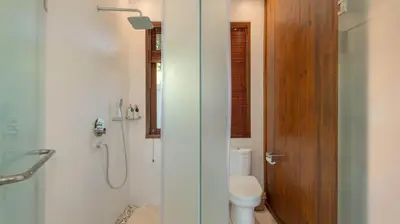 a bathroom with a shower and a toilet and a phone at Villa Aloui by Villa Finder in Kerobokan