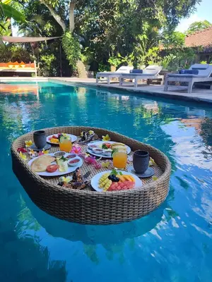 a table of food in the water near a swimming pool at Luxury 4BR Villa with 2 Pools & Garden in Seminyak