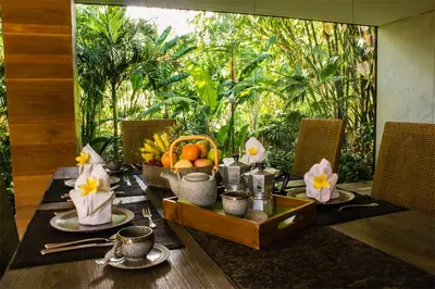 a dining table with a bowl of fruit on it at Luxury 4BR Villa with 2 Pools & Garden in Seminyak