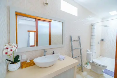 a bathroom with a sink and a toilet and a mirror at Selog Seven in Seminyak