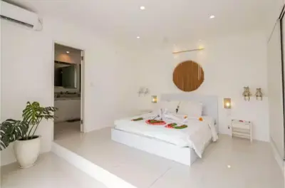 a white bedroom with a bed and a plant at PEKO VILLA - 1 BED - SEMINYAK in Seminyak