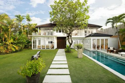 a house with a garden and a swimming pool at Villa Swarna by Nakula in Seminyak