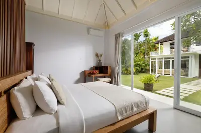 a bedroom with a bed and a large window at Villa Swarna by Nakula in Seminyak