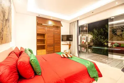 a bedroom with a large red bed with pillows at Villa Nikko I - 4Br Villa in Central Seminyak, Steps to Cafés & Shops in Seminyak
