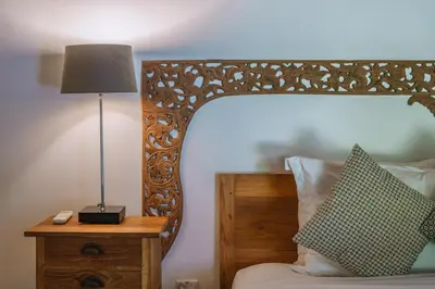 a bedroom with a bed with a lamp on a night stand at Villa Amore - Elegant 4-br Villa close to the beach in Canggu