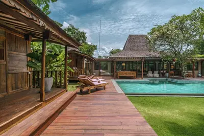 a villa with a swimming pool and a house at Villa Amore - Elegant 4-br Villa close to the beach in Canggu