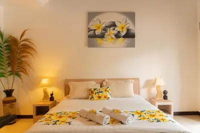 a bedroom with a bed with flowers on it at Wyanna Villa LEGIAN in Legian