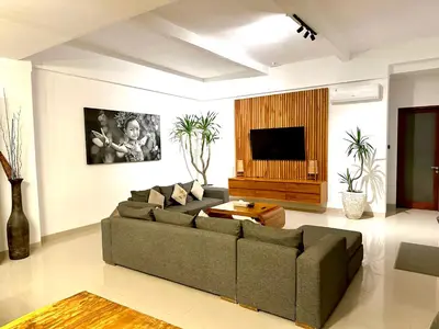 a living room with a couch and a flat screen tv at Villa Tepi Sungai - 6BR Luxury Private Pool Villa - Seminyak Sleeps 14 in Legian