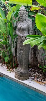 a statue of a woman standing next to a pool at Villa Tepi Sungai - 6BR Luxury Private Pool Villa - Seminyak Sleeps 14 in Legian
