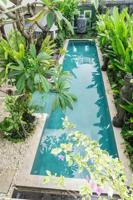 a swimming pool in a garden with plants at Villa Tepi Sungai - 6BR Luxury Private Pool Villa - Seminyak Sleeps 14 in Legian