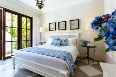 a bedroom with a white bed with blue pillows at Villa Kayan - Gorgeous 2BR Seminyak gem, fabulous location steps from restaurants, cafes and shopping in Seminyak