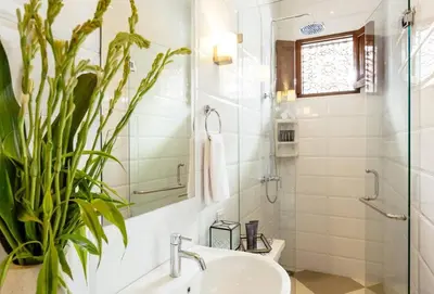 a bathroom with a sink and a shower and a plant at Villa Kayan - Gorgeous 2BR Seminyak gem, fabulous location steps from restaurants, cafes and shopping in Seminyak