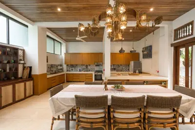 a kitchen with a large table and chairs and a kitchen with at The Lavana Ziza Living And Villas Seminyak in Kerobokan