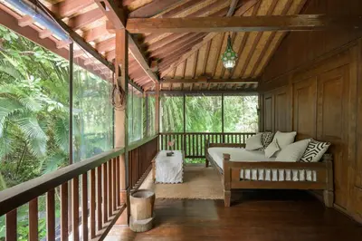 a screened in porch with a couch on a deck at The Lavana Ziza Living And Villas Seminyak in Kerobokan