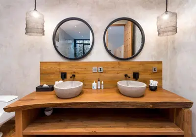 two sinks on a wooden counter with two mirrors at Villa Wolfe by Villa Finder in Seminyak