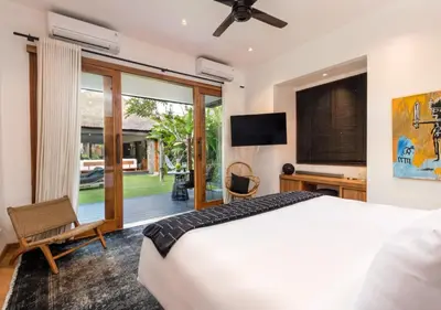 a bedroom with a bed and a sliding glass door at Villa Wolfe by Villa Finder in Seminyak