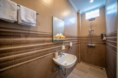 a bathroom with a sink and a mirror and a shower at Padma Lodge Legian in Seminyak