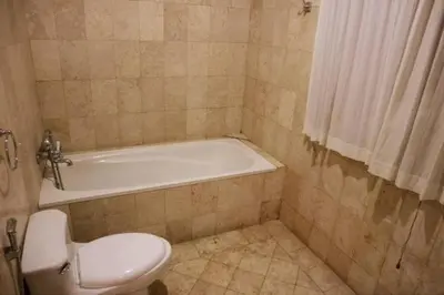 a bathroom with a tub and a toilet and a sink at KUTA - 4BR Villa with Private XL Pool in Kuta