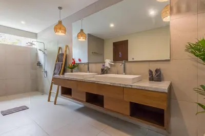 a bathroom with two sinks and a large mirror at Ajiorqo Villa in Seminyak