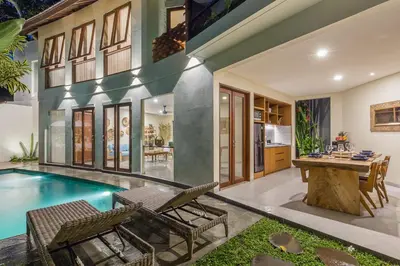 a home with a swimming pool and a table and chairs at Ajiorqo Villa in Seminyak