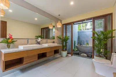 a bathroom with two sinks and a large mirror at Ajiorqo Villa in Seminyak