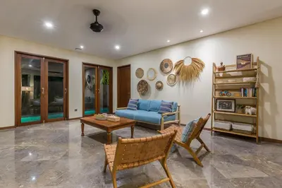 a living room with a blue couch and a table at Ajiorqo Villa in Seminyak
