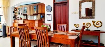 a dining room with a wooden table and chairs at Villa Cantik Kuta Regency in Kuta