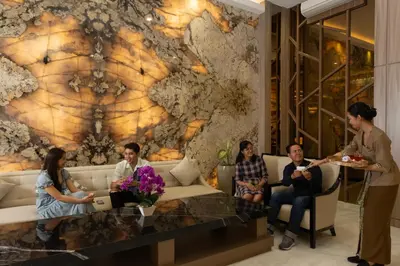 a group of people sitting in a room with a wall at Dream of Aventus Hotel Kuta in Kuta