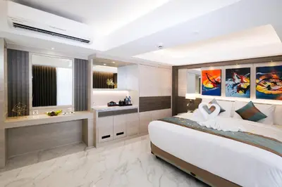 a bedroom with a large bed and a bathroom at Dream of Aventus Hotel Kuta in Kuta