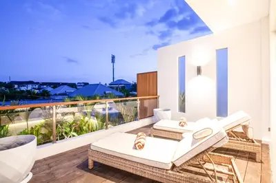 a balcony with white furniture and a view of the ocean at Exquisite 4Bd Gem, 5min to Finns Coastal Vibe in Canggu