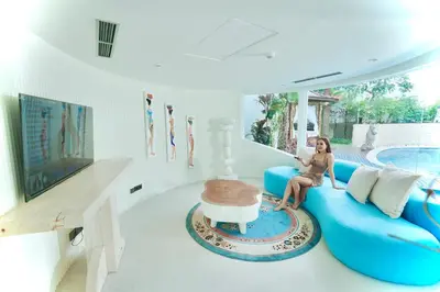 a woman sitting on a blue couch in a living room at Villa Rose in Seminyak
