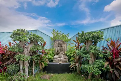 a statue in the middle of a garden with trees at Villa Rose in Seminyak