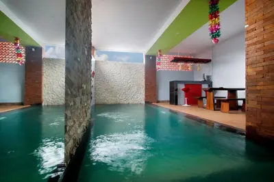 a pool of water in a room with a table at Valomia Guest House in Kerobokan