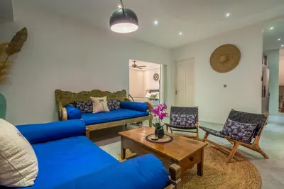 a living room with a blue couch and a table at Villa Alchemy Private 4 BR Eat Street 10 steps to Revolver Cafe in Seminyak
