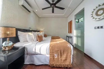 a bedroom with a large bed and a ceiling fan at Villa Alchemy Private 4 BR Eat Street 10 steps to Revolver Cafe in Seminyak