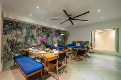 a dining room with a table and blue chairs at Villa Alchemy Private 4 BR Eat Street 10 steps to Revolver Cafe in Seminyak