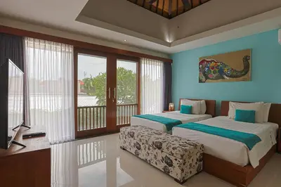 a bedroom with two beds and a balcony at Lacasa2 Villa Legian With Butler in Legian