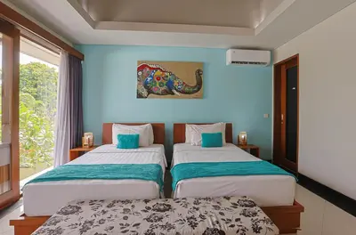two beds in a room with blue walls at Lacasa2 Villa Legian With Butler in Legian
